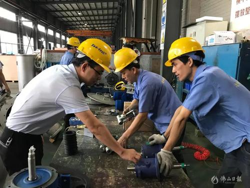 三技精机技术部经理陈红军在和员工研究产品研发